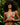 Woman wearing a green bikini with red floral patterns against a leafy background