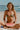 Woman in a bikini holding a watermelon slice on a beach