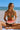 Woman in a bikini holding a watermelon slice on a beach