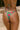 Woman wearing brazilian cut watermelon print bikini on beach