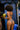 Woman in a bikini holding a coconut against a blue background