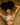 Woman wearing a colorful bikini against a wooden panel background