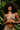 Woman wearing a green bikini with red floral patterns against a leafy background