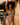 Woman in a black and white patterned bikini standing under a thatched roof.