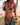 Woman in a patterned bikini and cover-up standing on a beach.