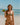 Woman in a colorful bikini holding a watermelon on a beach