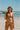 Woman in a colorful bikini holding a watermelon on a beach