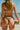 Person in a colorful bikini holding a watermelon on a beach