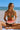 Woman in a bikini holding a watermelon slice on a beach
